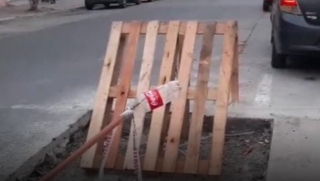 ¡ Un peligro ! Señalizaron un bache con una botella y una tarima